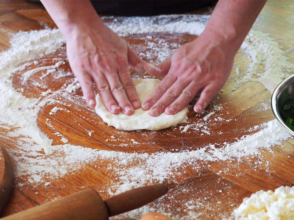 flattening a dough ball with fingers