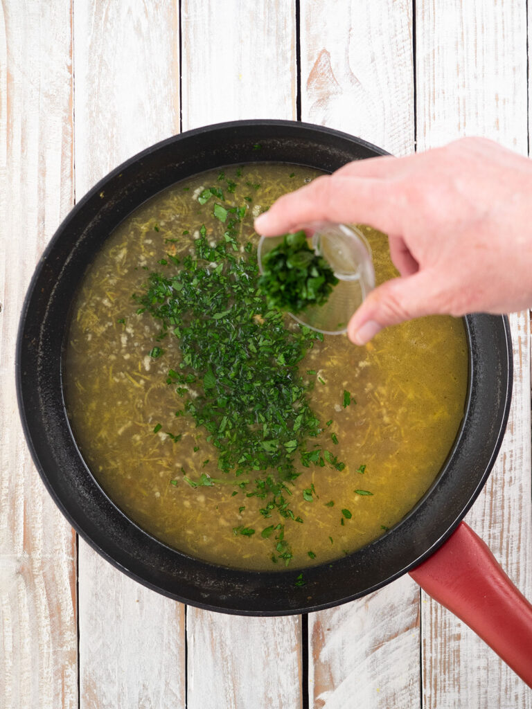 adding parsley to the pan
