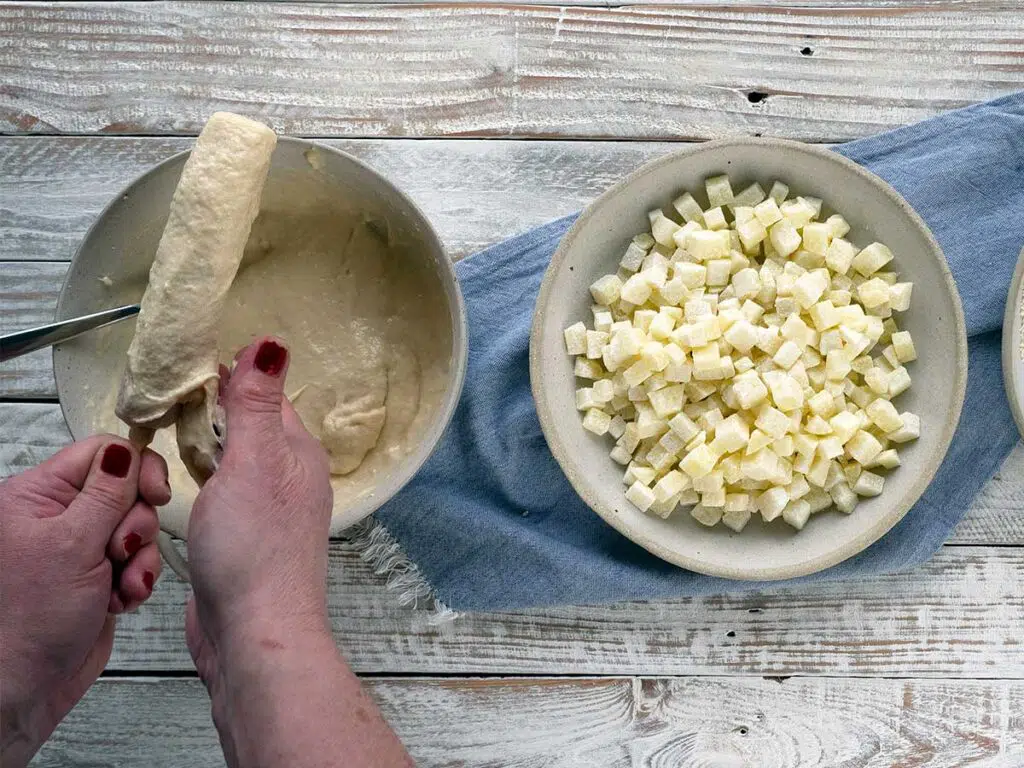 coating hot dog with batter