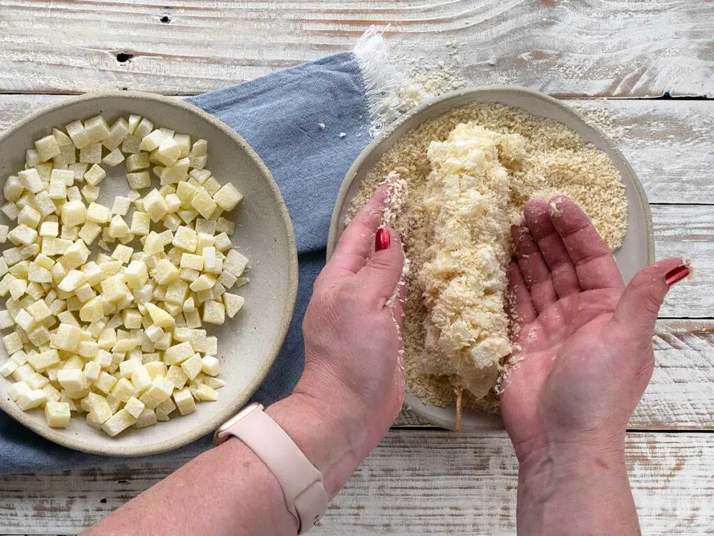 covering hot dog with panko crumbs