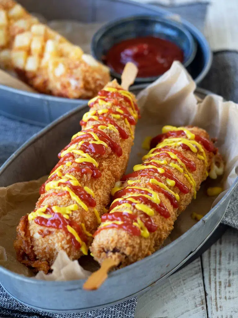 korean corn dogs drizzled with tomato sauce and mustard