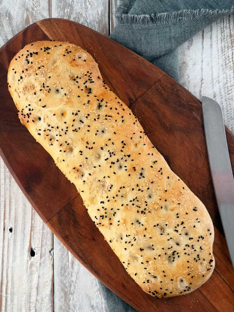 turkish bread on a wooden board with a bread knife