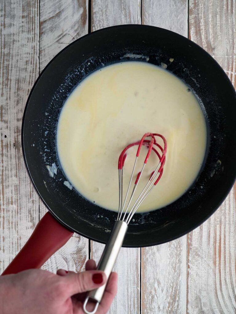 whisking sauce in the pan