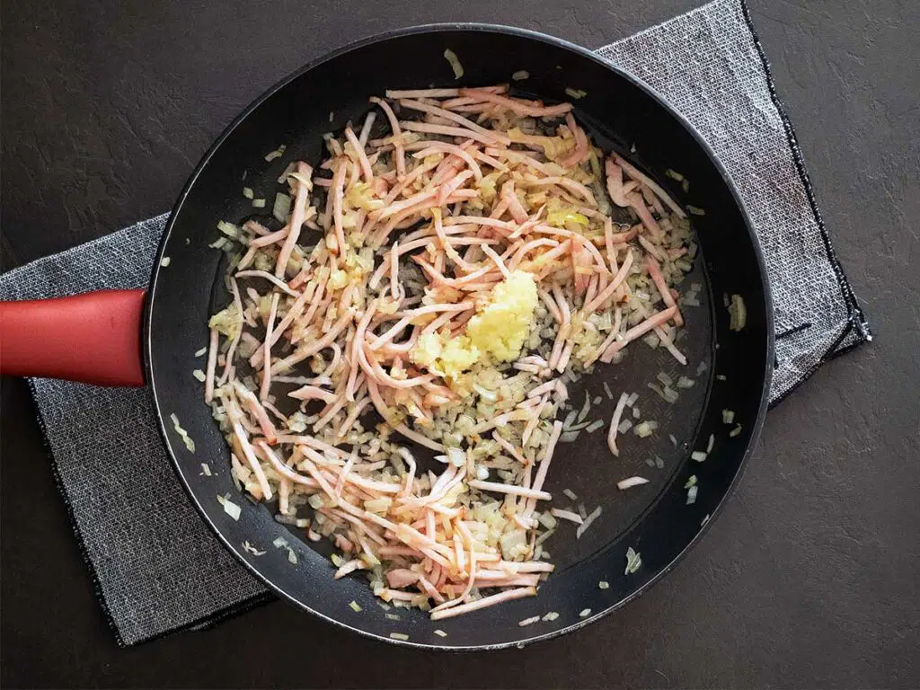 adding garlic and white wine to the pan