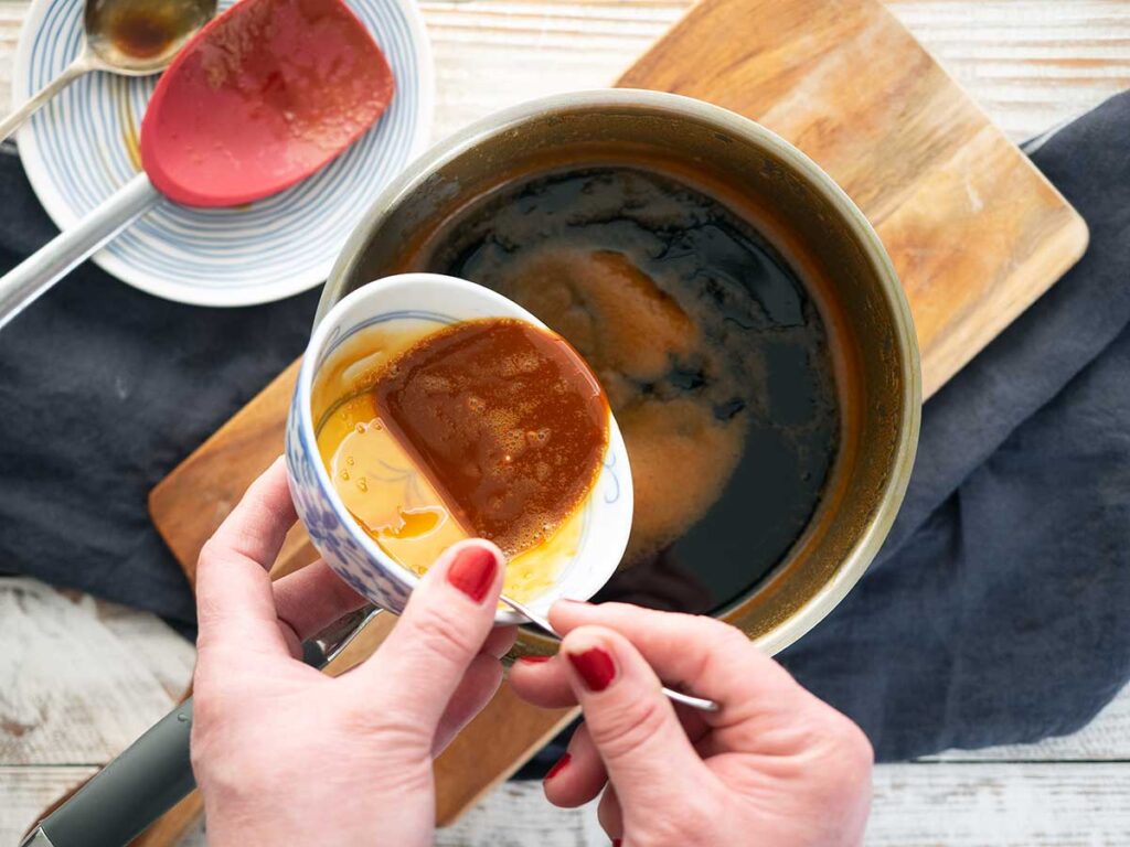 pouring cornflour slurry into the teriyaki sauce in the pot