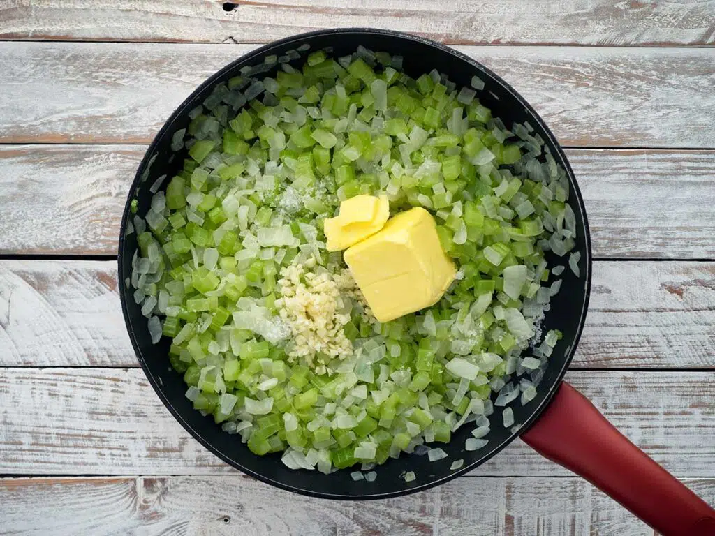 adding butter and garlic to the sautéd vegetables