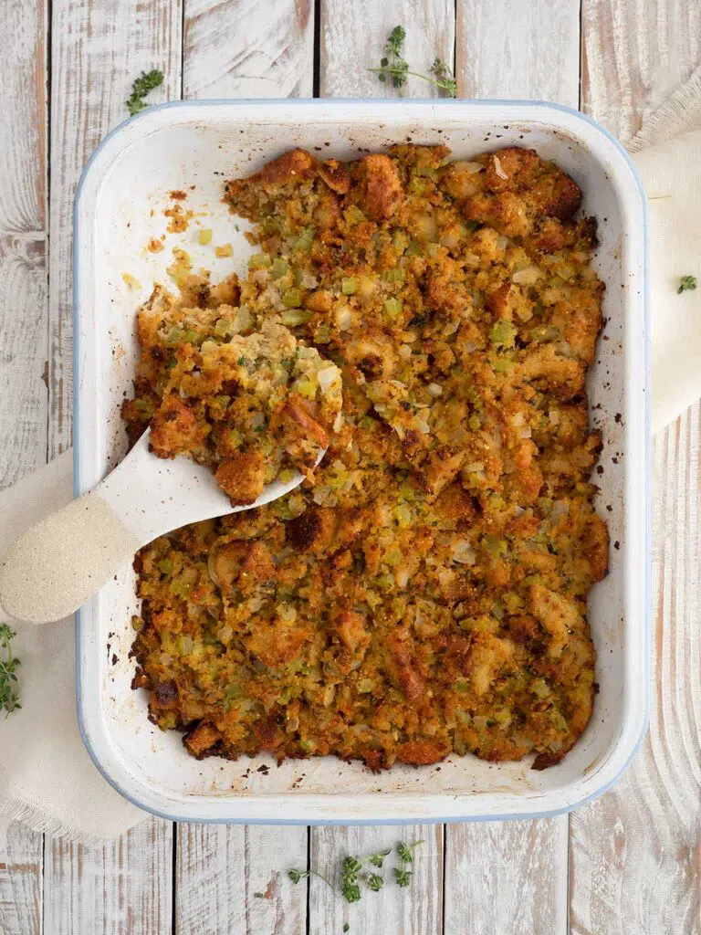 baked cornbread dressing in a baking dish with a spoon
