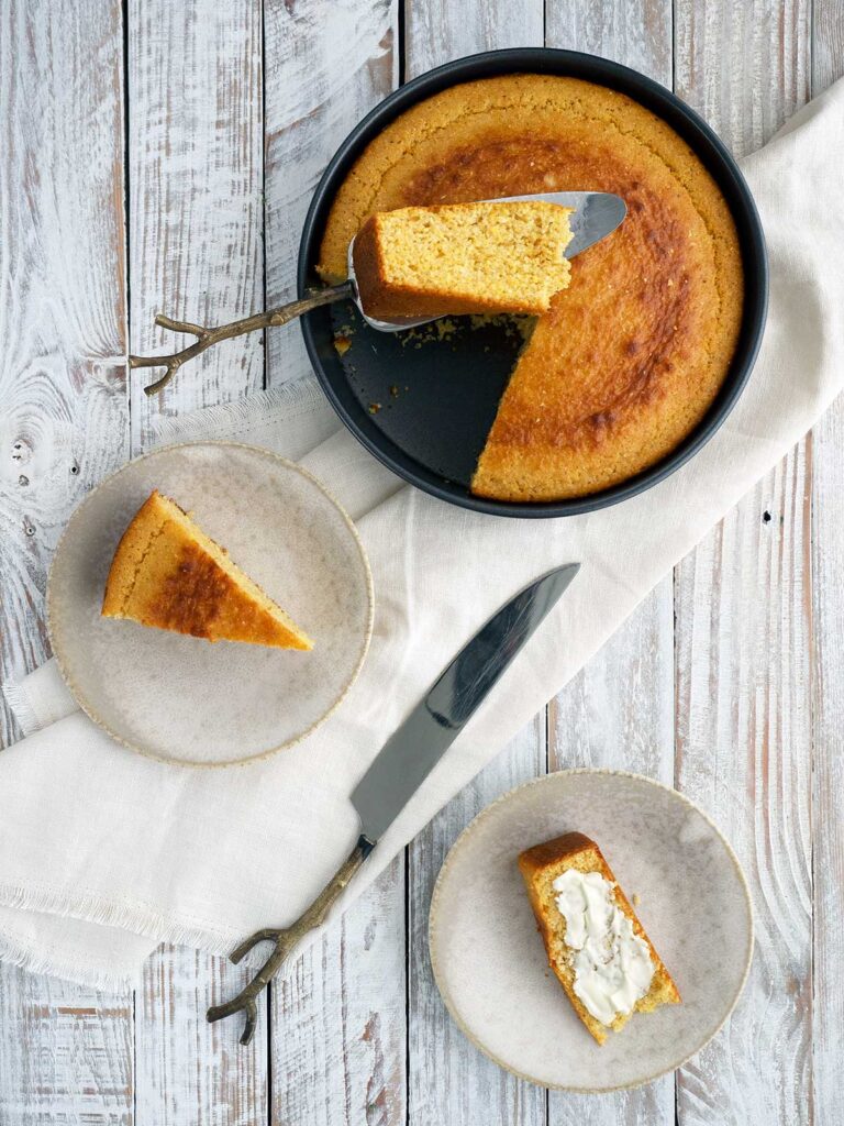 cornbread slices on plates and main round in a tin