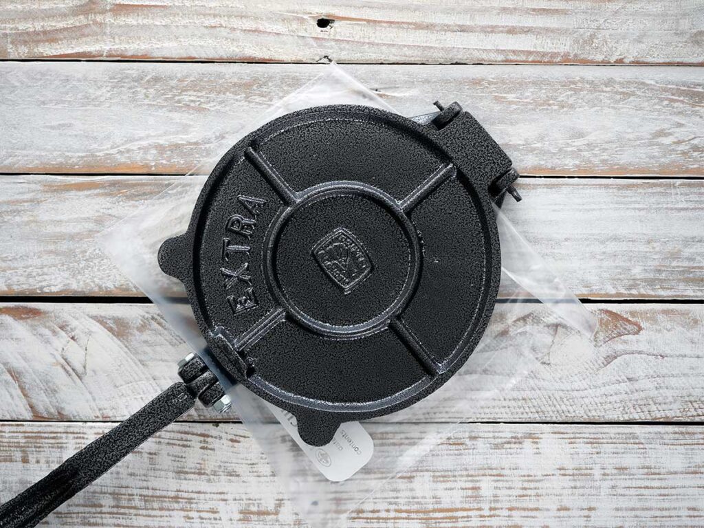 using a tortilla press to flatten the dough