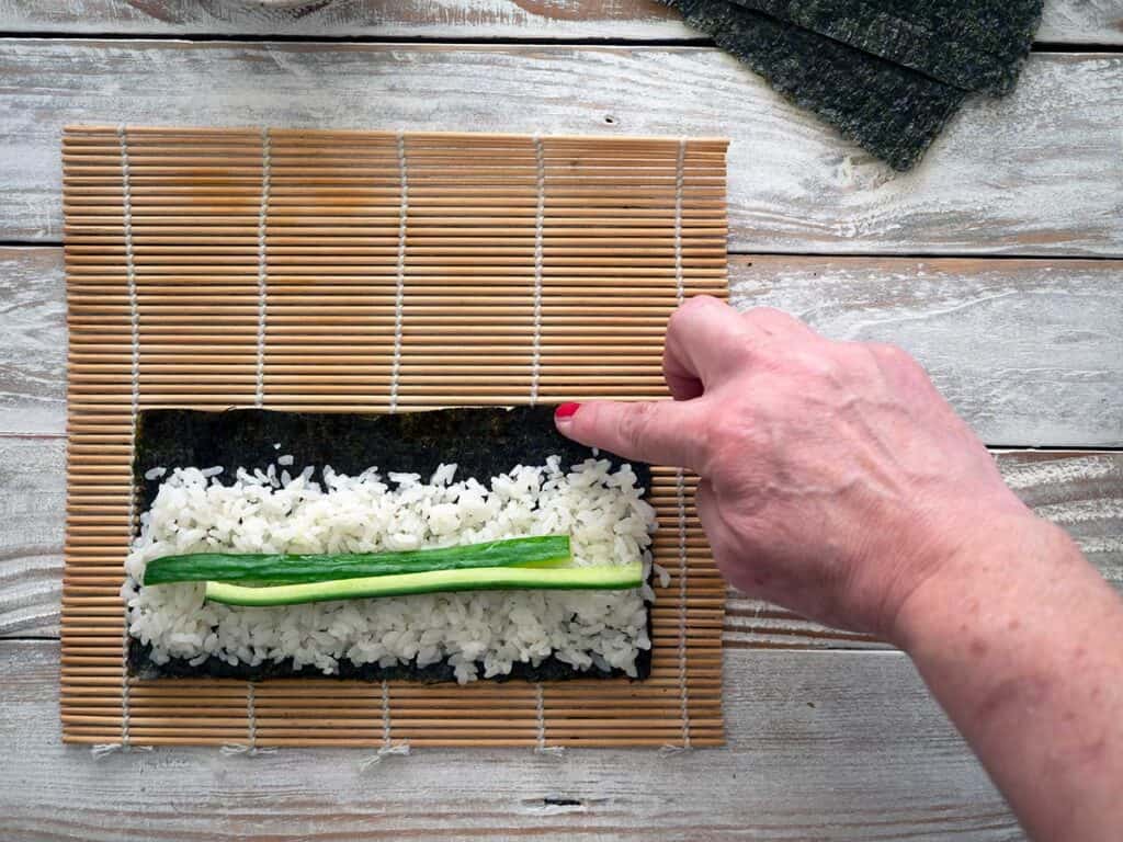 wetting the edge of the nori sheet with a damp finger