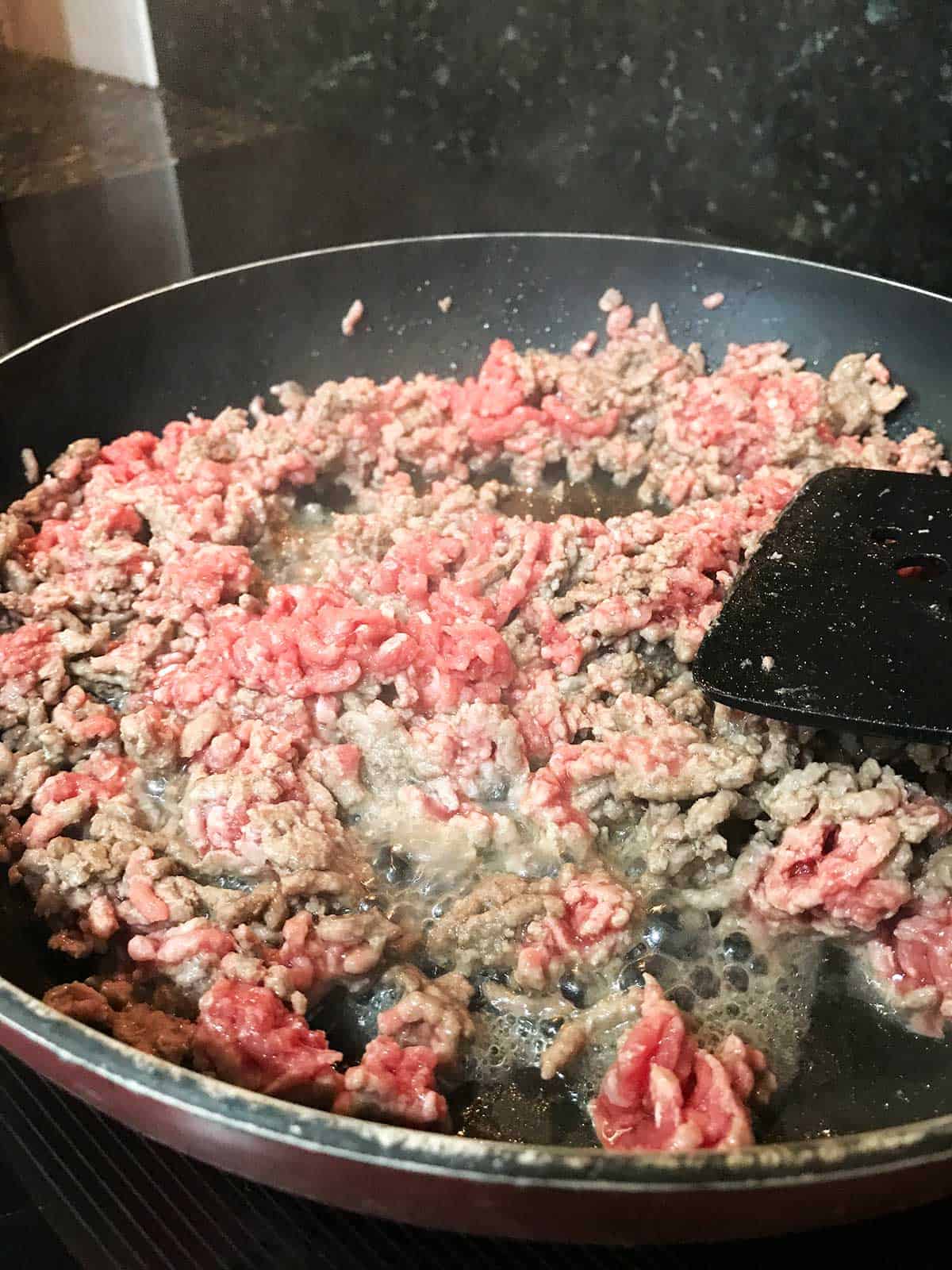 Browning the beef mince / ground beef in a frying pan.