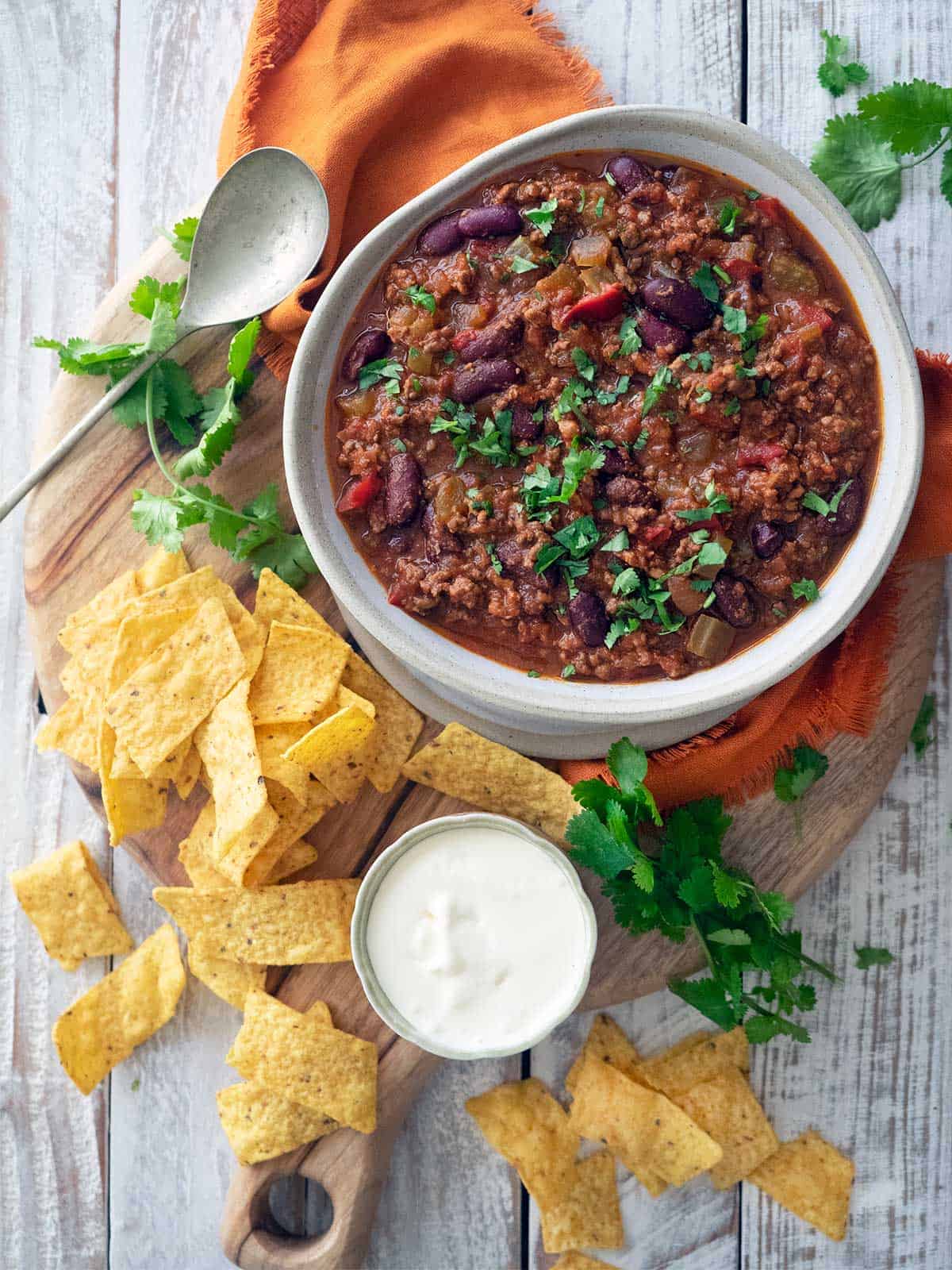 Finished recipe with corn chips, sour cream and fresh coriander / cilantro.