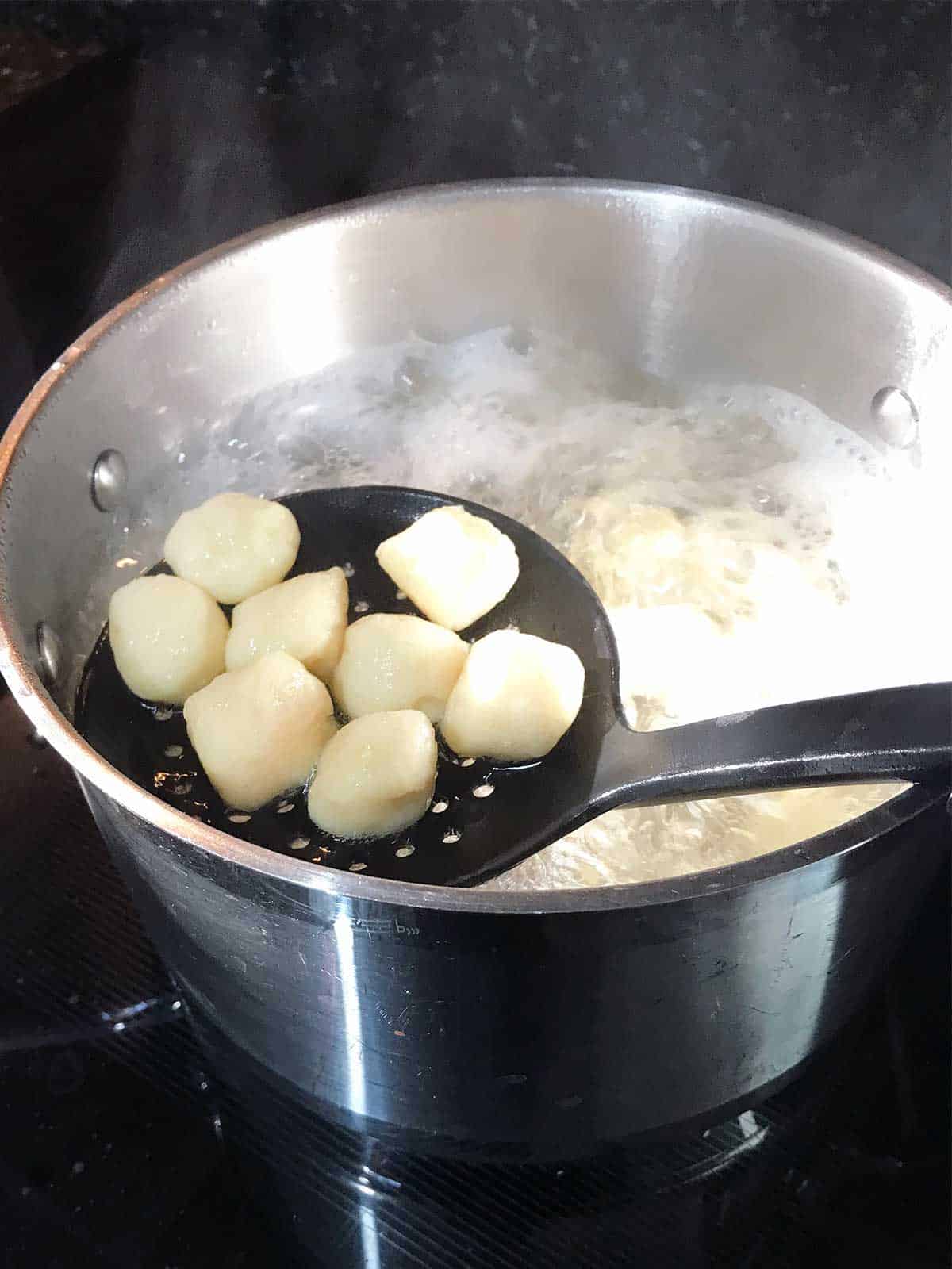 Cooking gnocchi in a large pot of salted water.