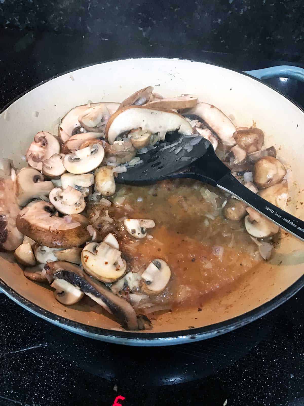 Adding the wine to the cooking pan.