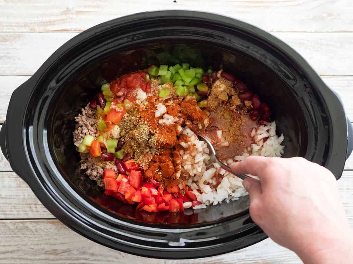 Mixing the ingredients in the slow cooker bowl.