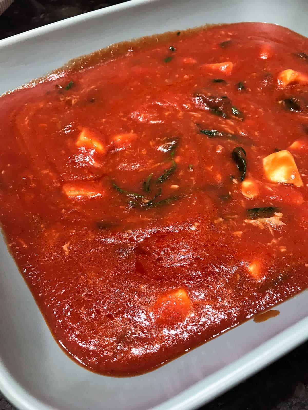 Tomato sauce placed in a baking dish ready for the gnocchi to be added.