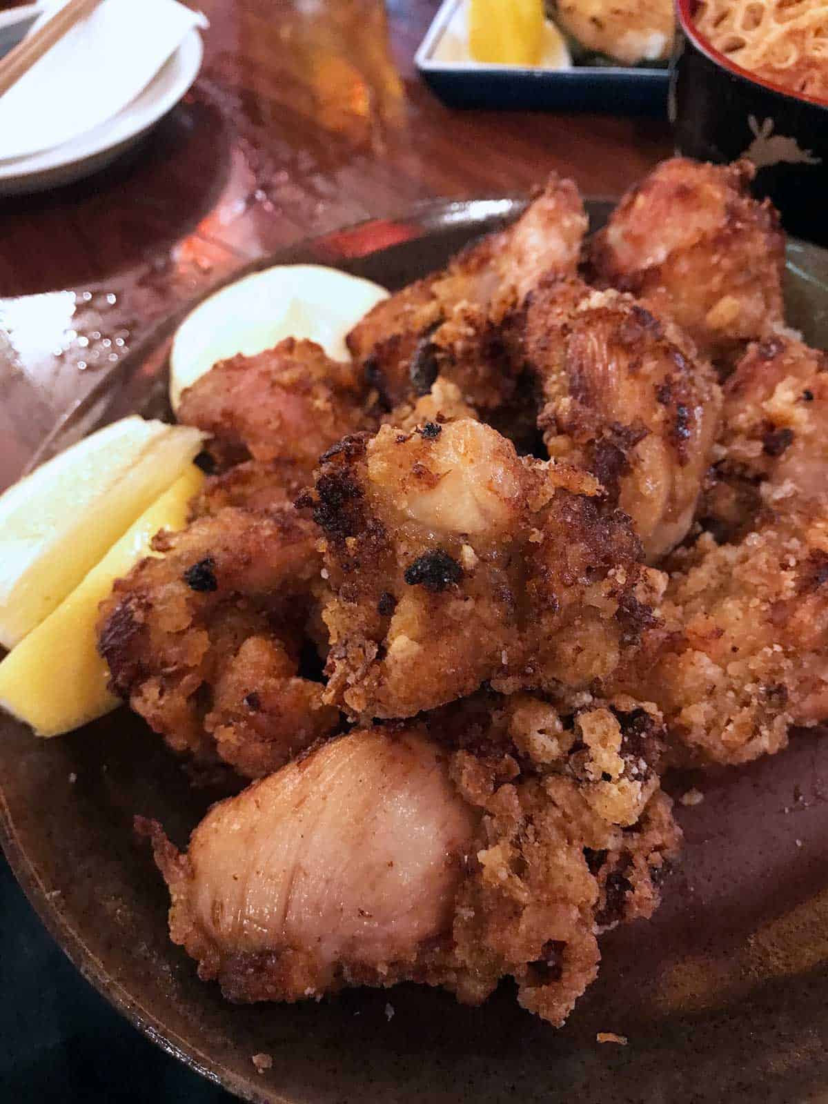 Karaage chicken on a plate with a slice of lemon.