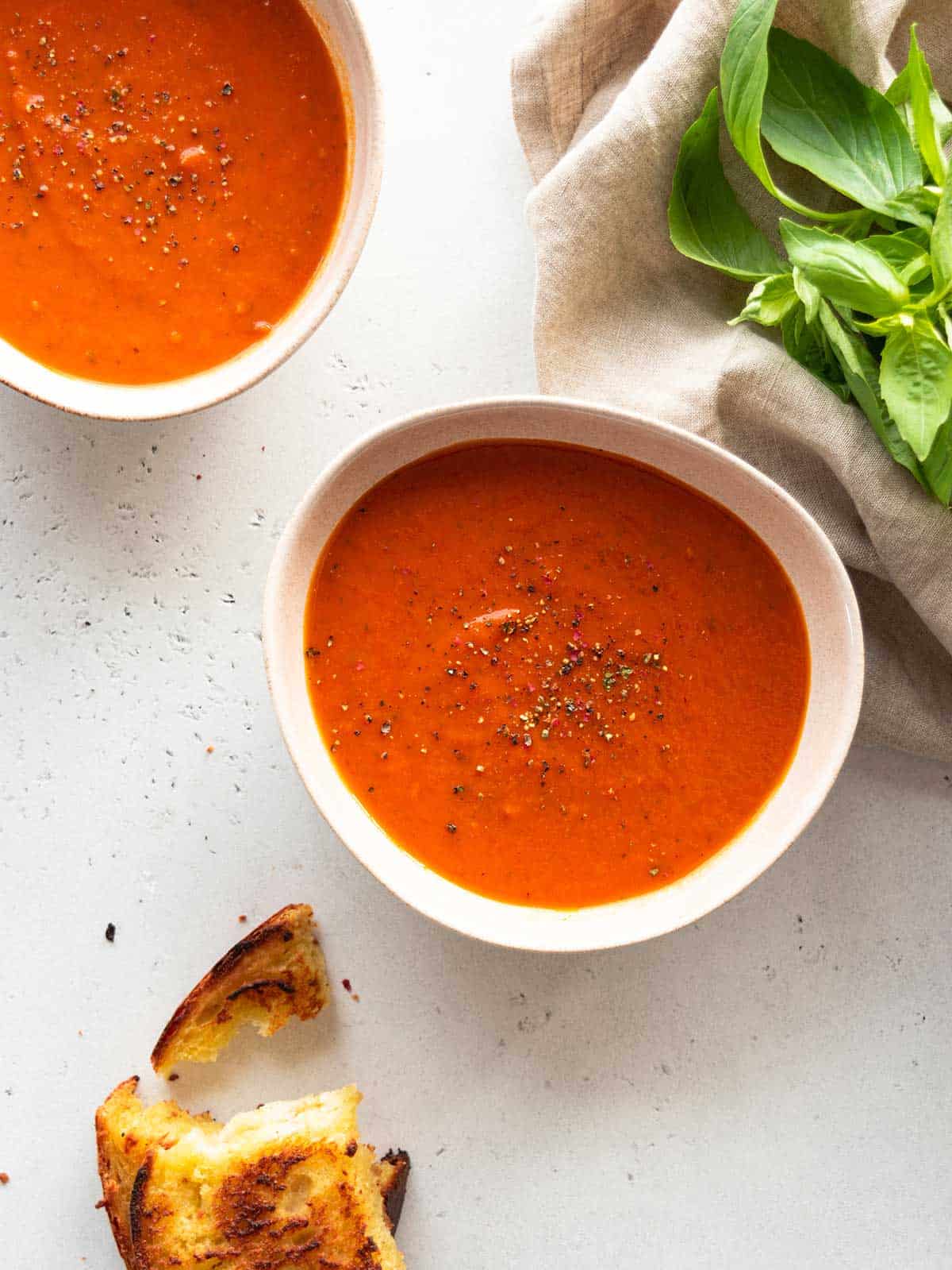 White bowls filled with creamy tomato gin soup.