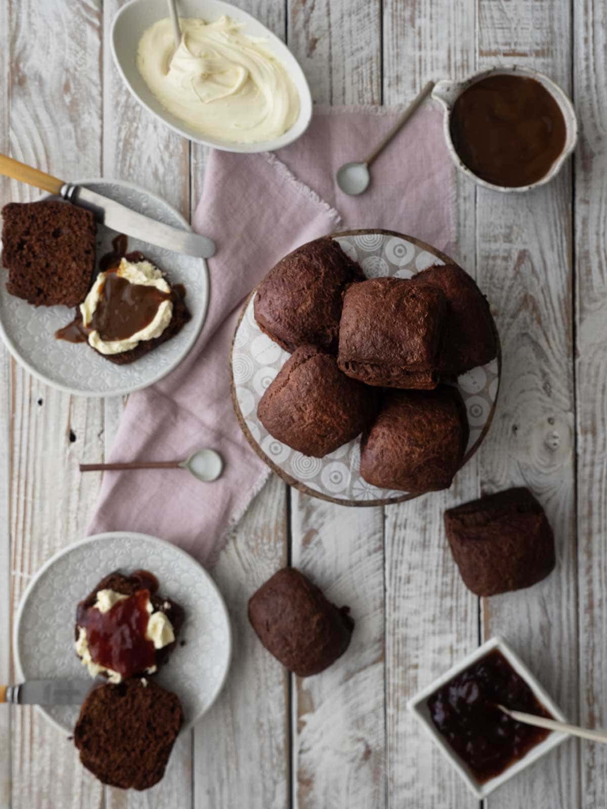 Lemonade chocolate scones ready to serve with jam, cream, and caramel sauce.