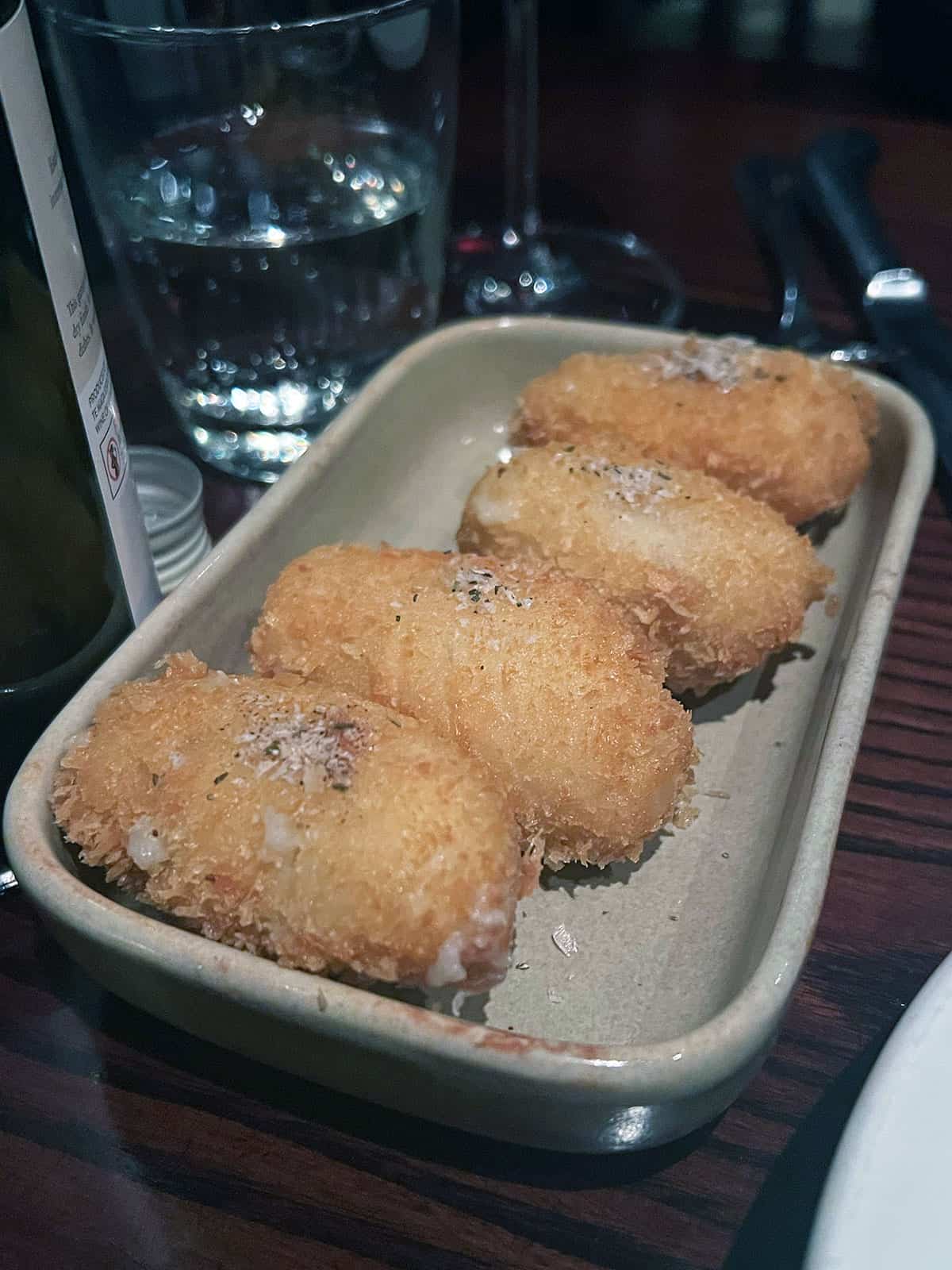 Duck fat potato croquettes on a serving plate.