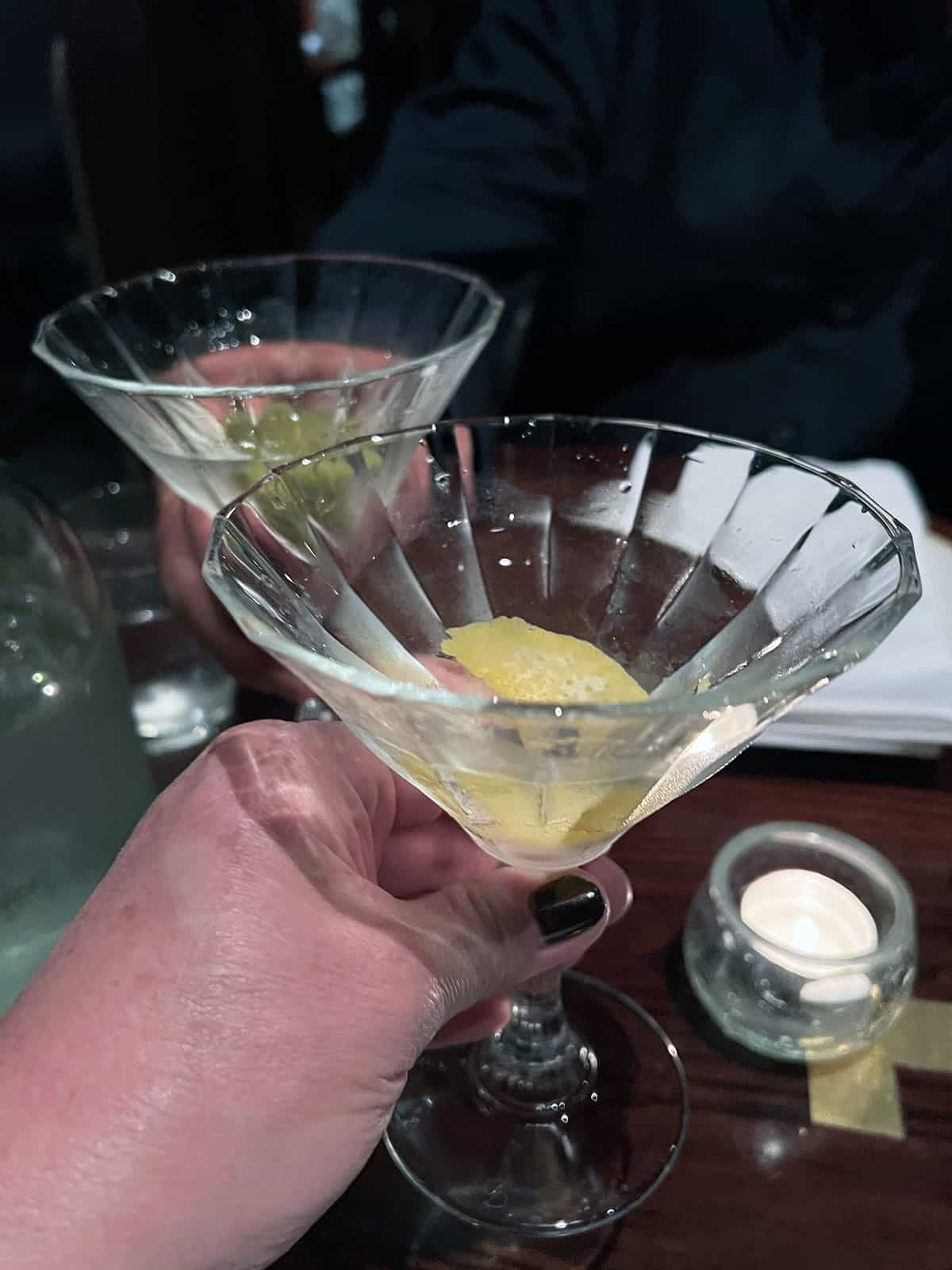 Two martini glasses clinking to cheers.