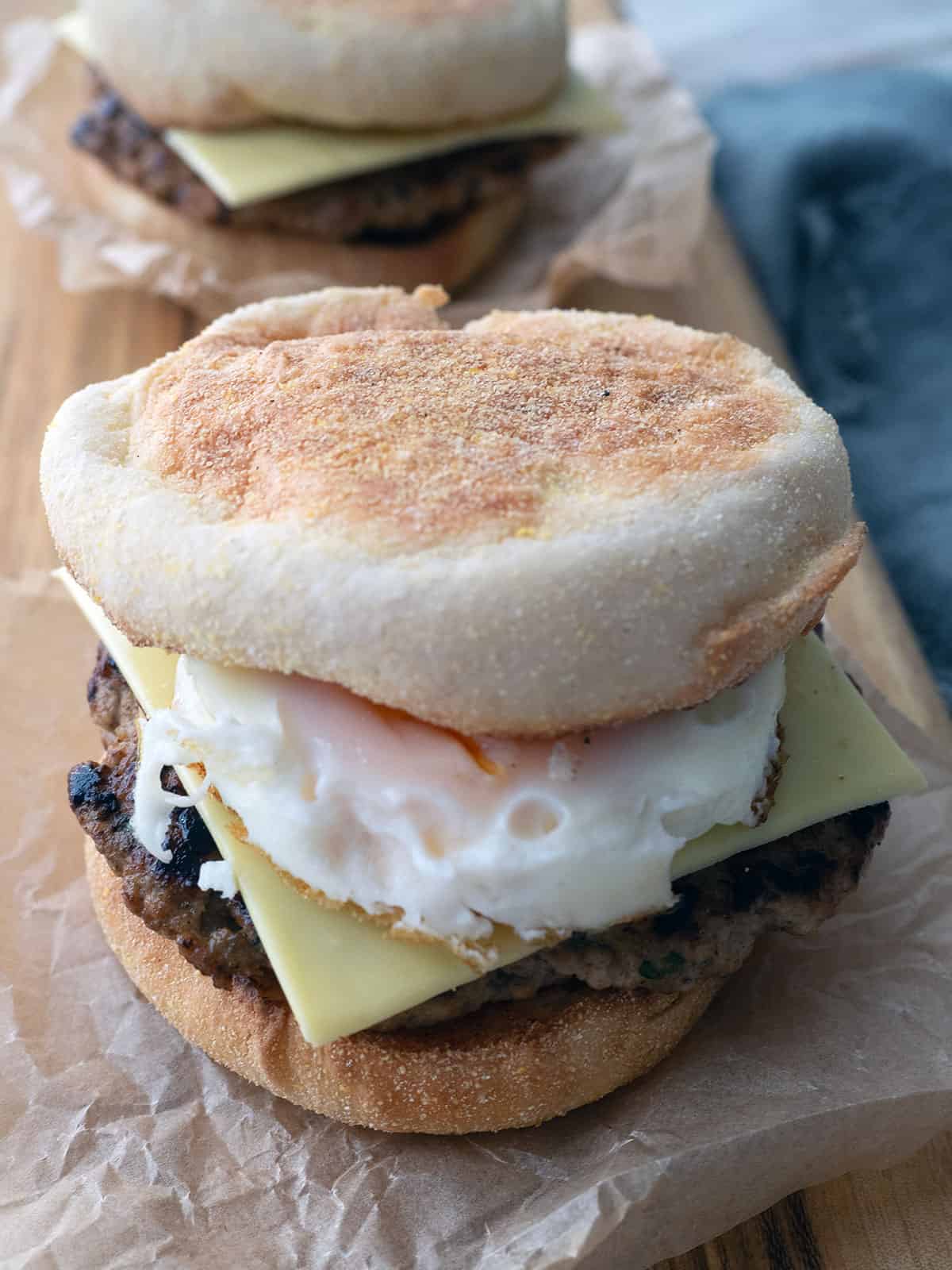 English muffin with fried egg, pork sausage patty, and cheese.