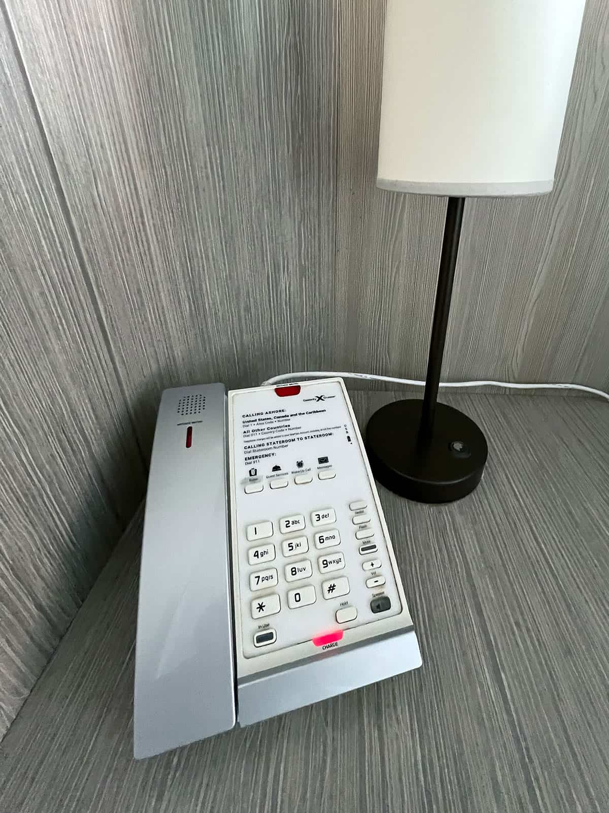 Telephone on bedside table next to a reading lamp.