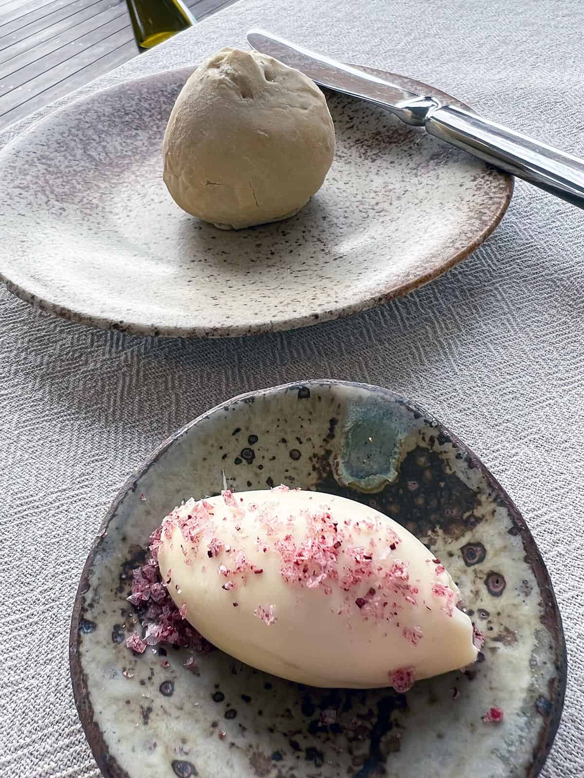 Bread roll and butter with pink salt.